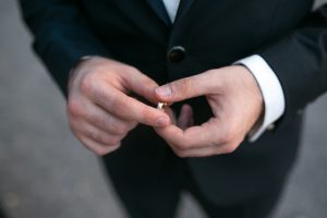 groom holding a wedding ring and waits for bride